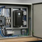 Open industrial control panel illustrating SCCR considerations, with a VFD, circuit breaker, fuses, contactors, terminal blocks, and organized wiring.